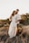shallow focus photo of man hugging woman in white long-sleeved dress