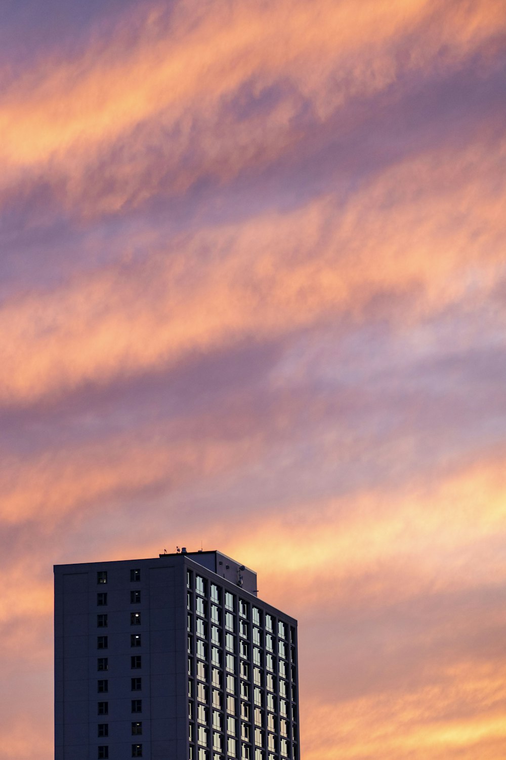 gray high-rise building under a cloudy sky during golden hour