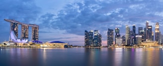 A panoramic view of a modern hotel exterior illuminated at dusk.