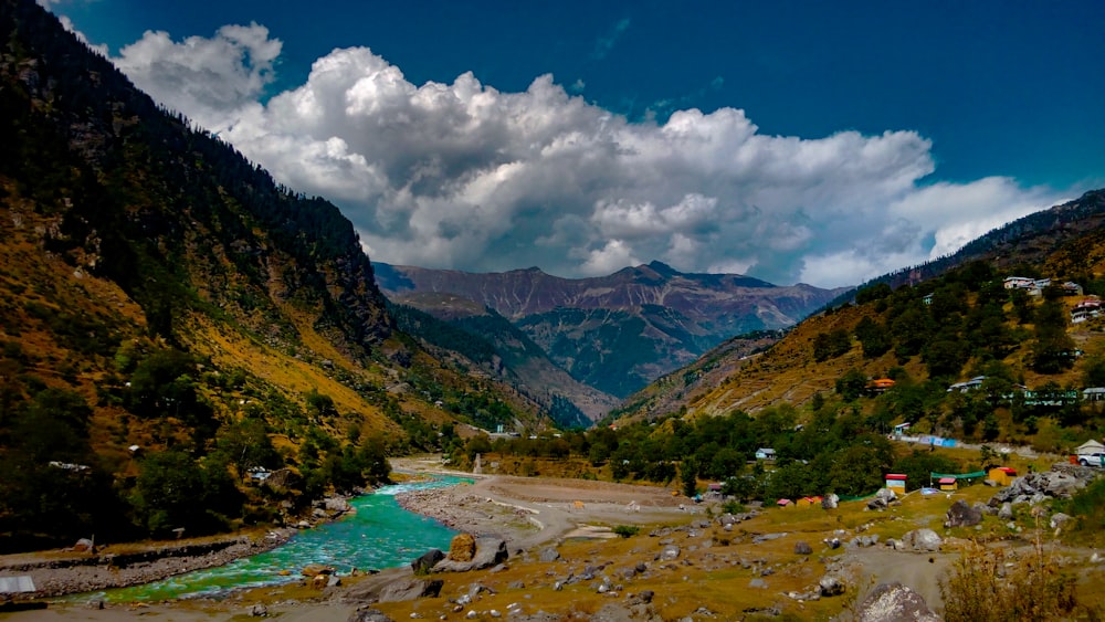 river between mountains under blue cloudy sky