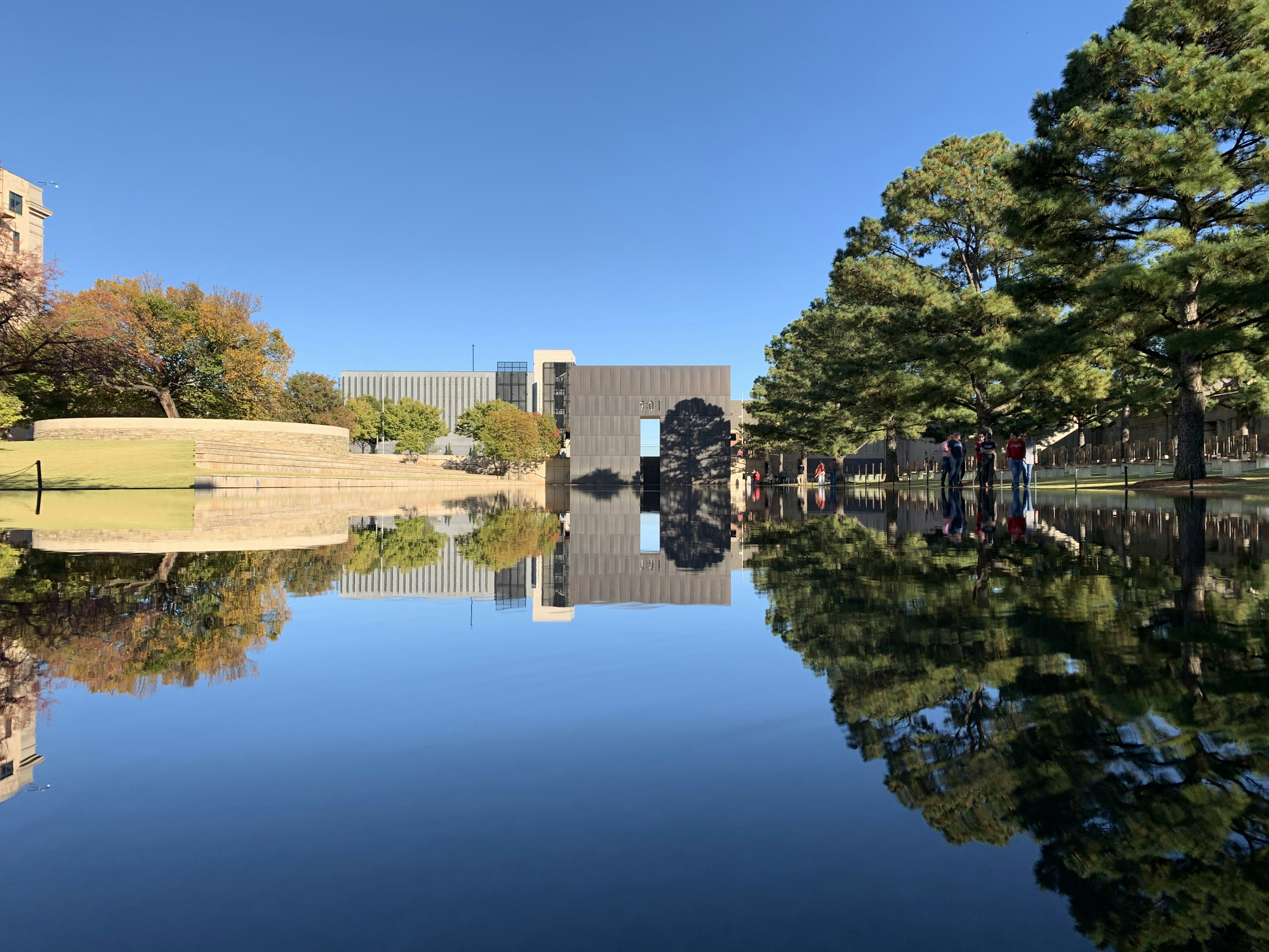 reflection of trees and building under blue sky