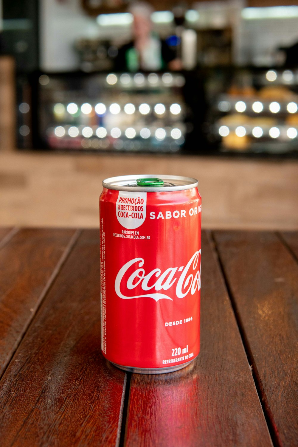茶色のテーブルの上のコカ・コーラソーダ缶