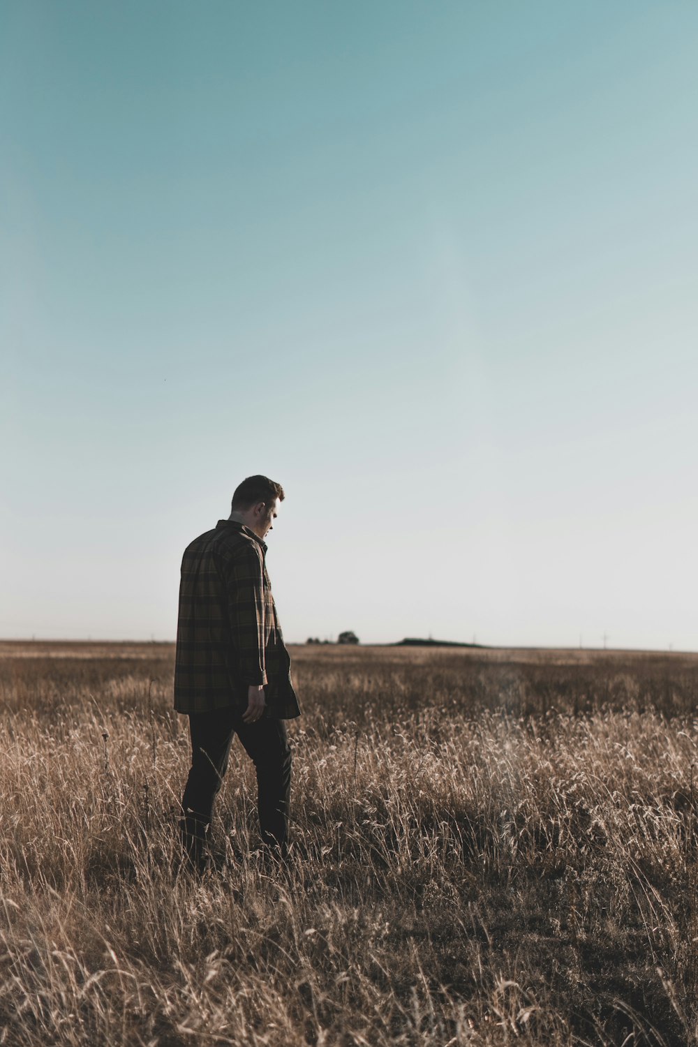 man wearing black jacket standing on field during daytime