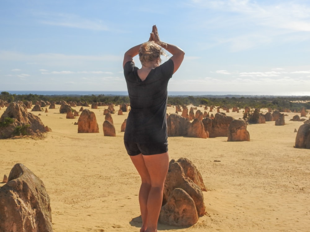 woman wearing black blouse standing near the stone