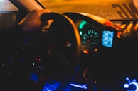 Nighttime photo of a luxury car's illuminated dashboard and steering wheel.