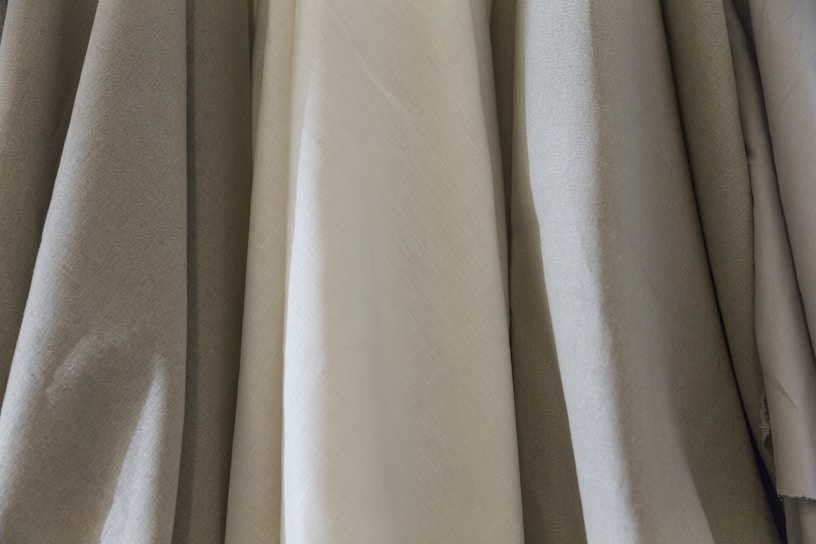 A sleek display of folded elegant fabrics in muted tones, highlighting the simplicity of bulk fashion.