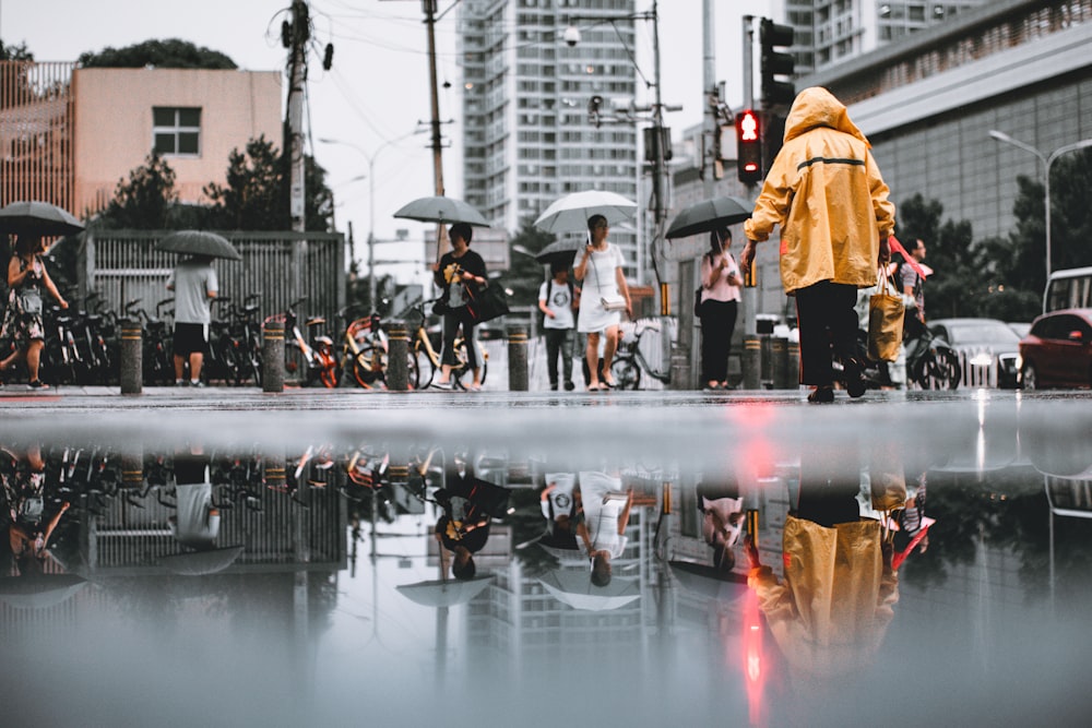 Gente con paraguas caminando en la carretera