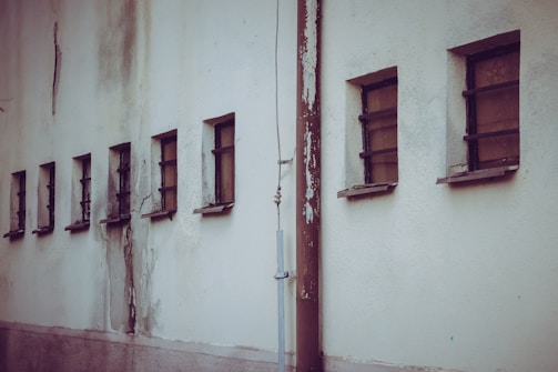 A row of sturdy iron windows lined up, ready for installation.