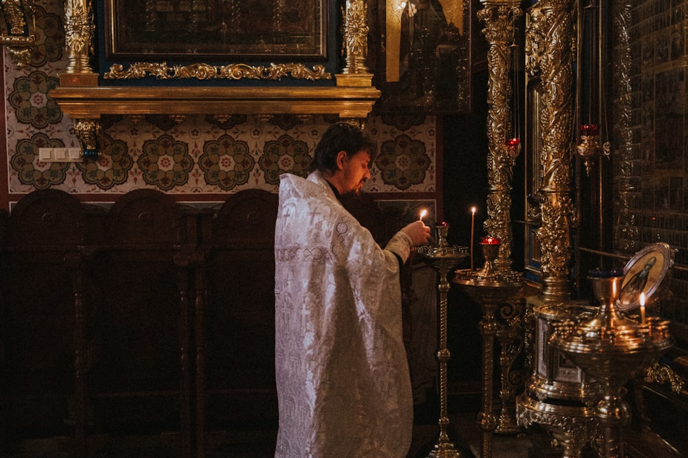 hombre vestido con túnica blanca sosteniendo canle