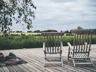 two brown wooden armchairs