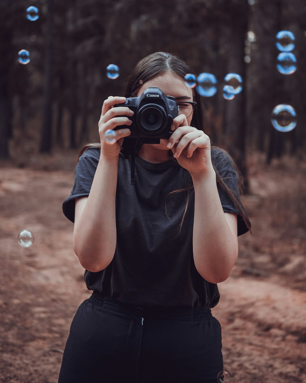 woman taking photo near trees