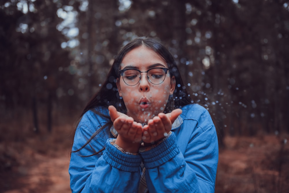 woman blowing flower buds