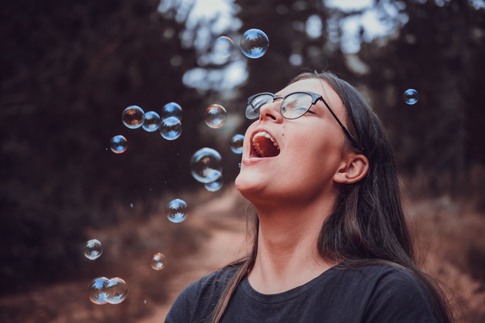 selective focus photo of woman facing up surrounded by bubbles