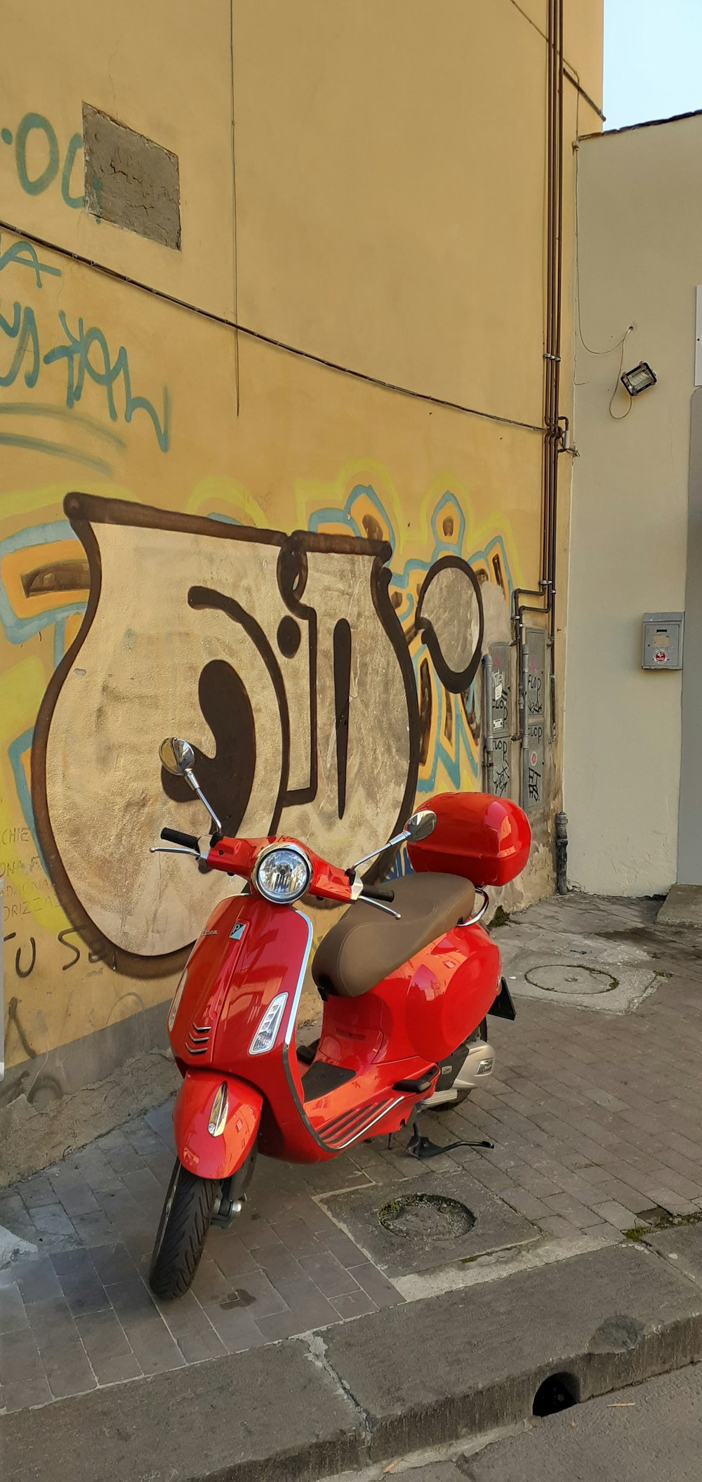 red motor scooter parked on pavement