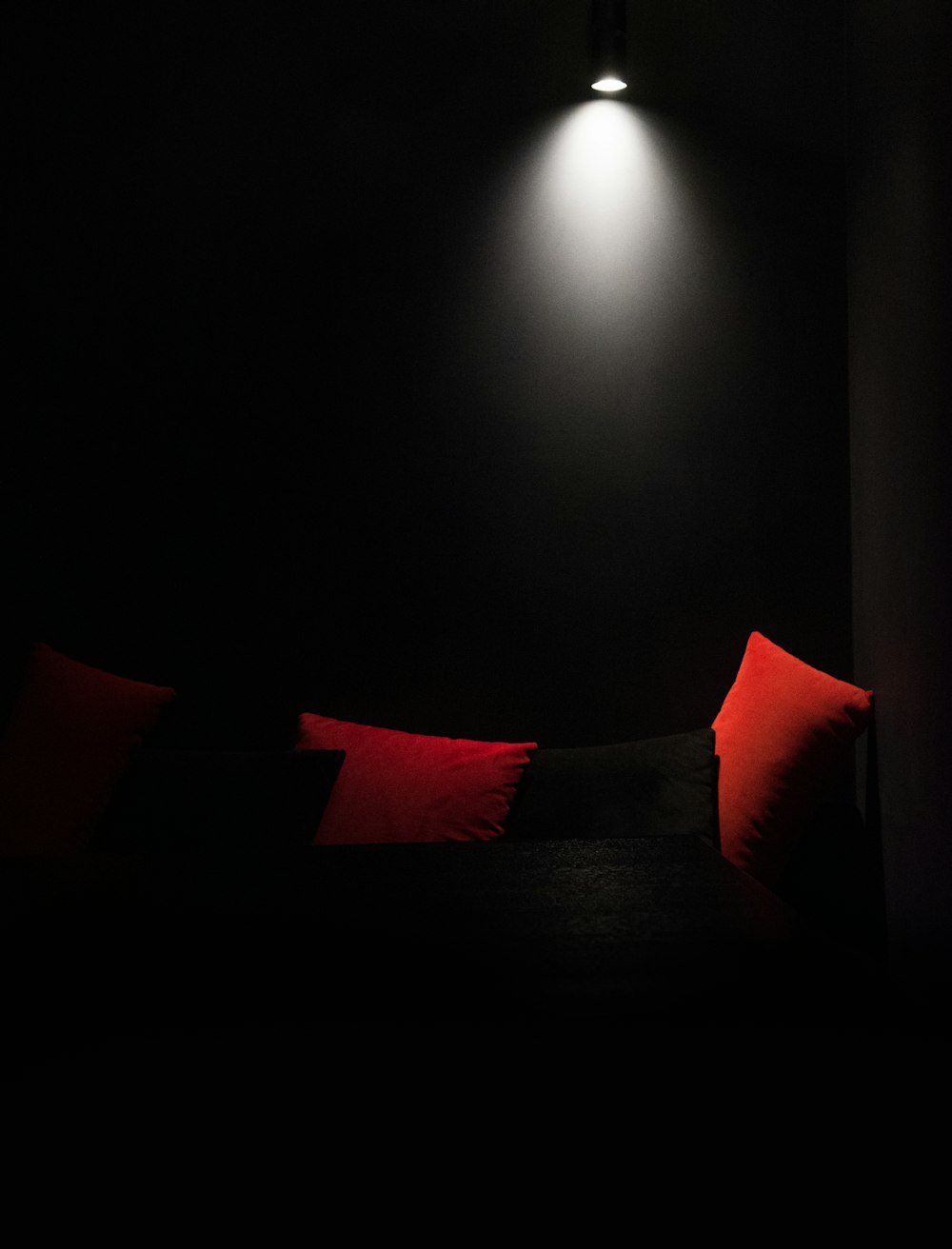 a dark room with a couch and a lamp