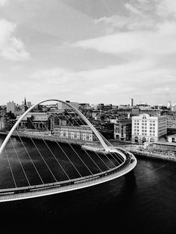 grayscale photography of bridge near city