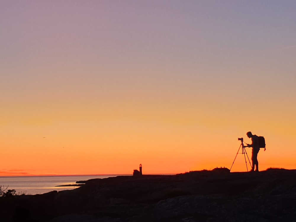silhouette of man standing in front of tripod