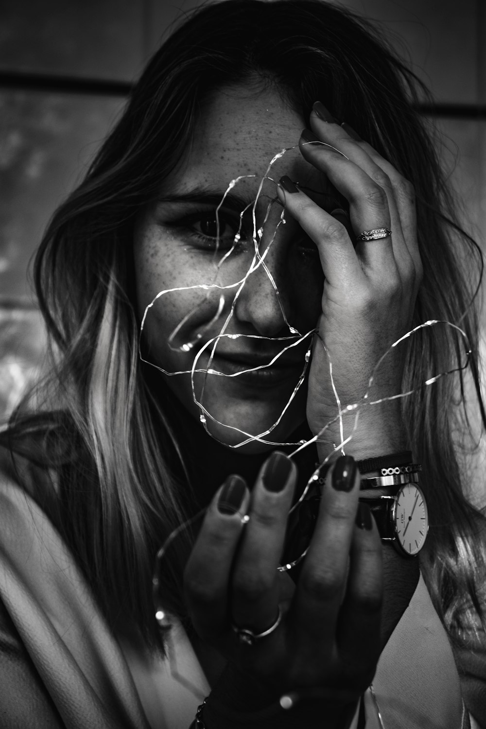 grayscale photo of woman holding string lights