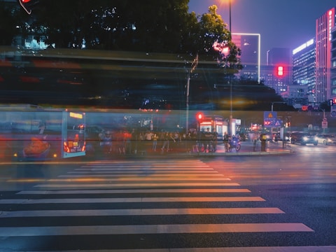 Slow-motion capture of bustling streets with colorful lights and people in motion.