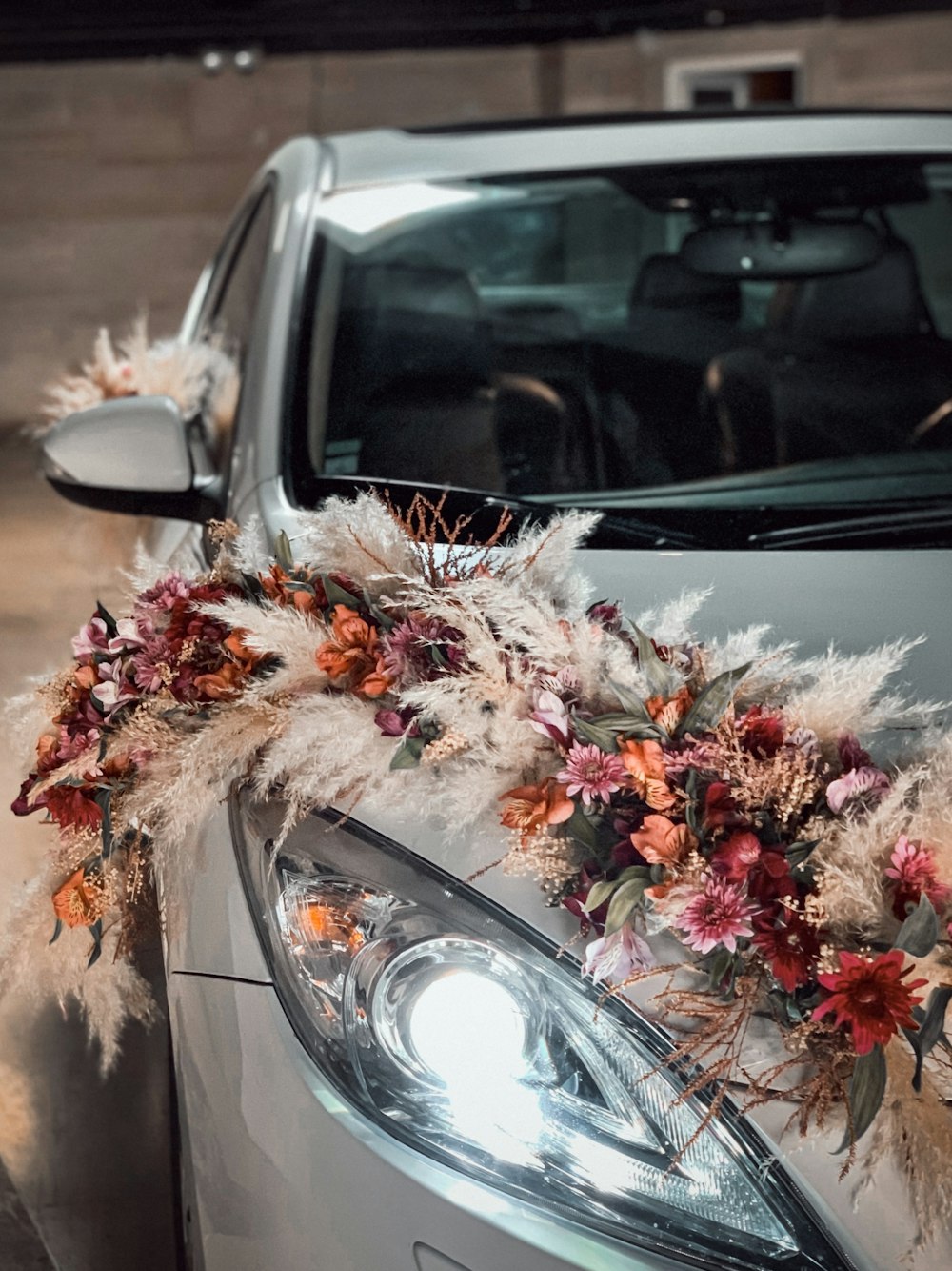 assorted color of flowers wrapped on a white car inside turned-on light room