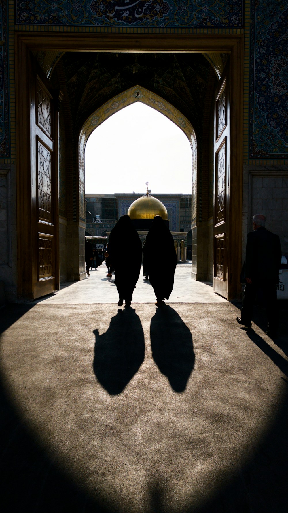 two person inside arch-design doorway during daytime