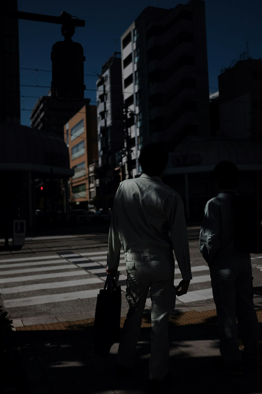 woman wearing white dress shirt and white pants walking on pedestrian line