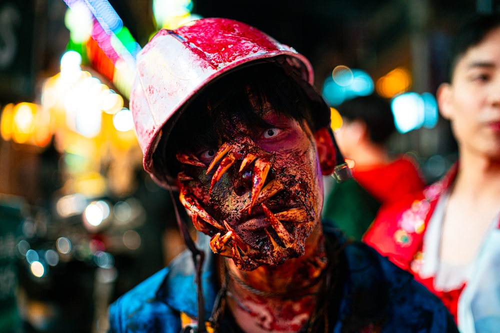 a man with a bloody face and a hat on