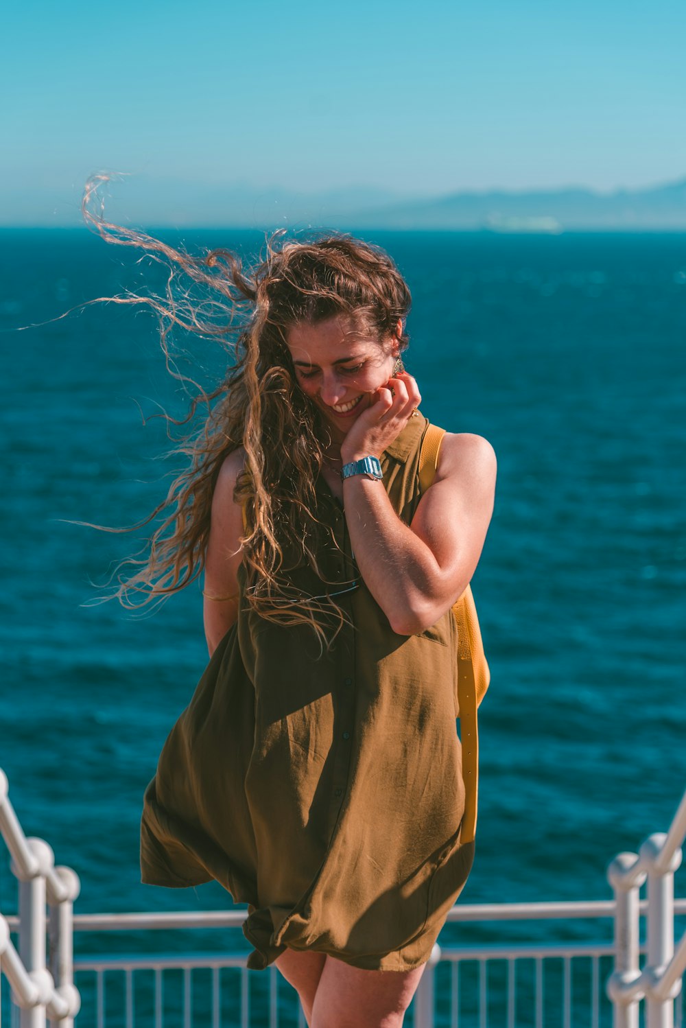 a woman walking on a pier talking on a cell phone