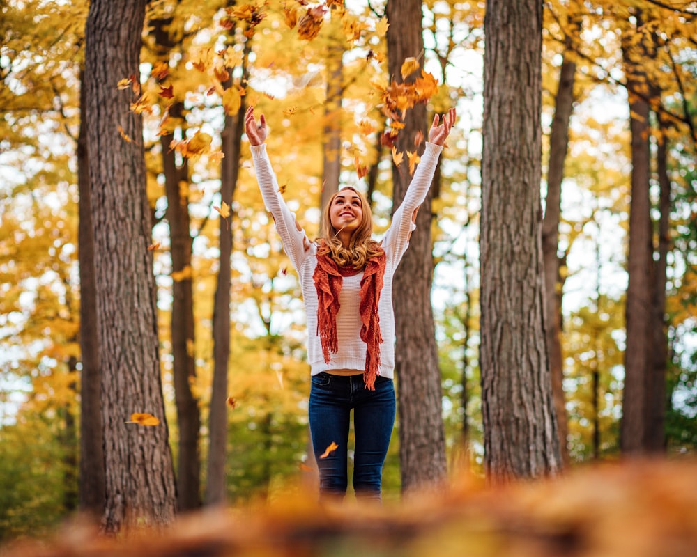 woman tossing dried leaves