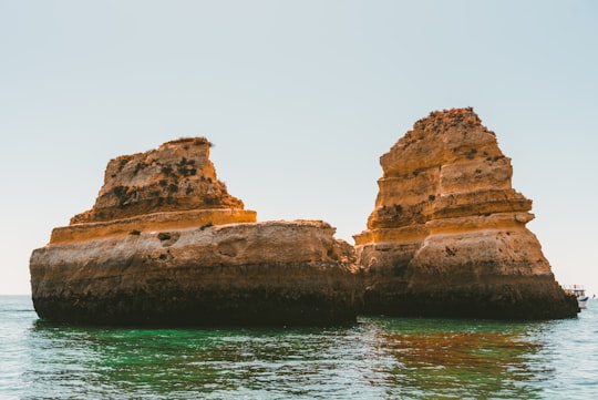 brown rock formations in Praia do Camilo Portugal