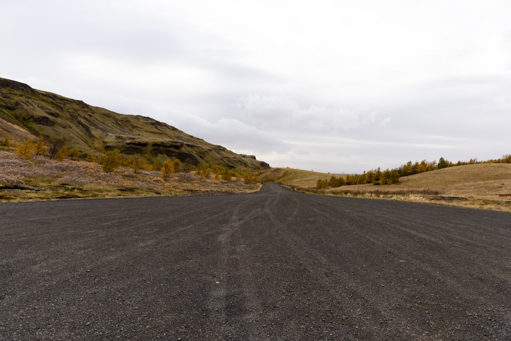 gray concrete road and green mountain