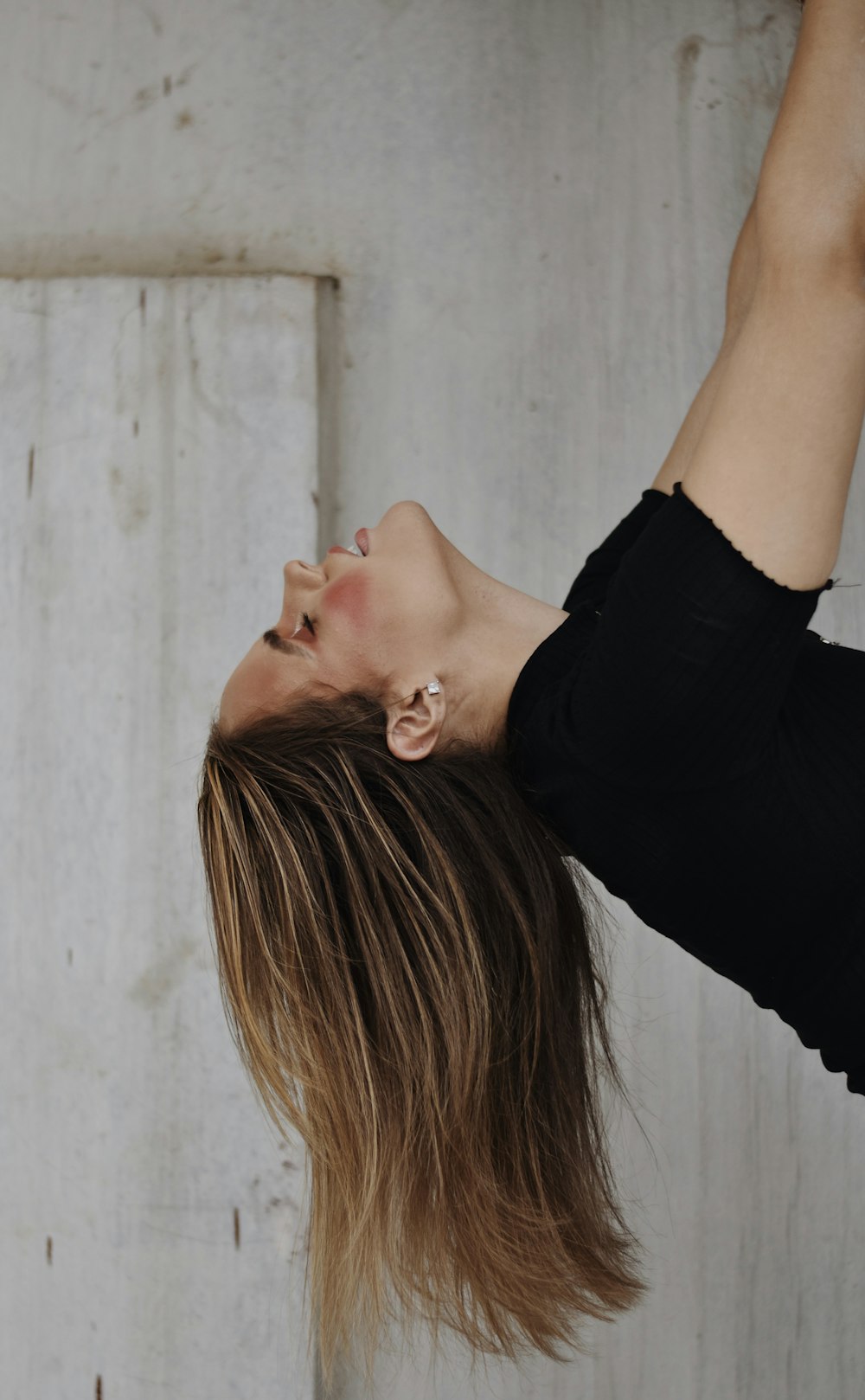 woman wearing black top beside wall