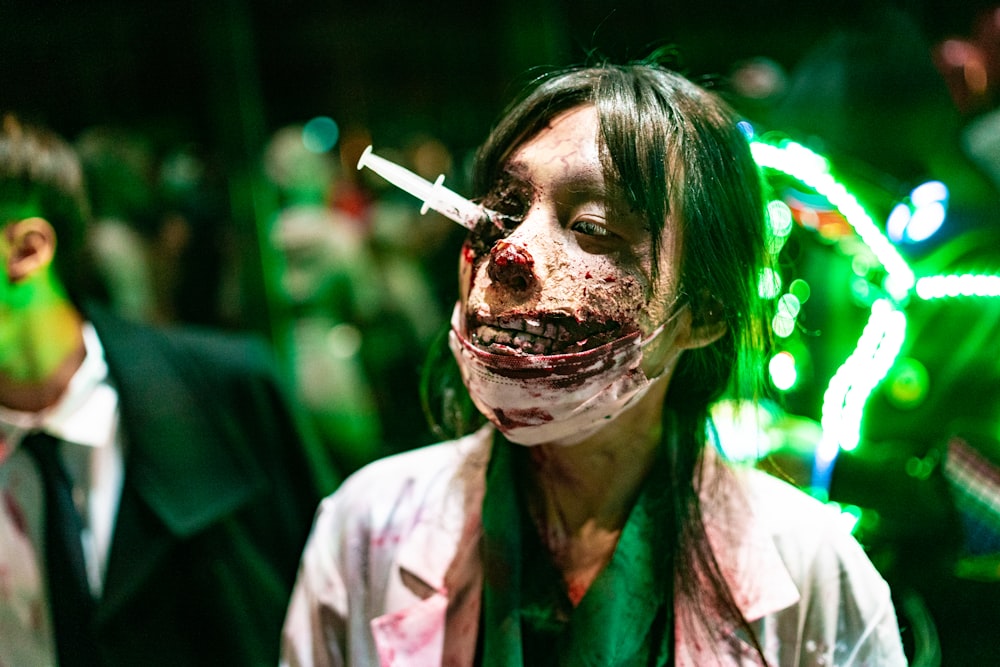 a woman with blood on her face and a cigarette in her mouth