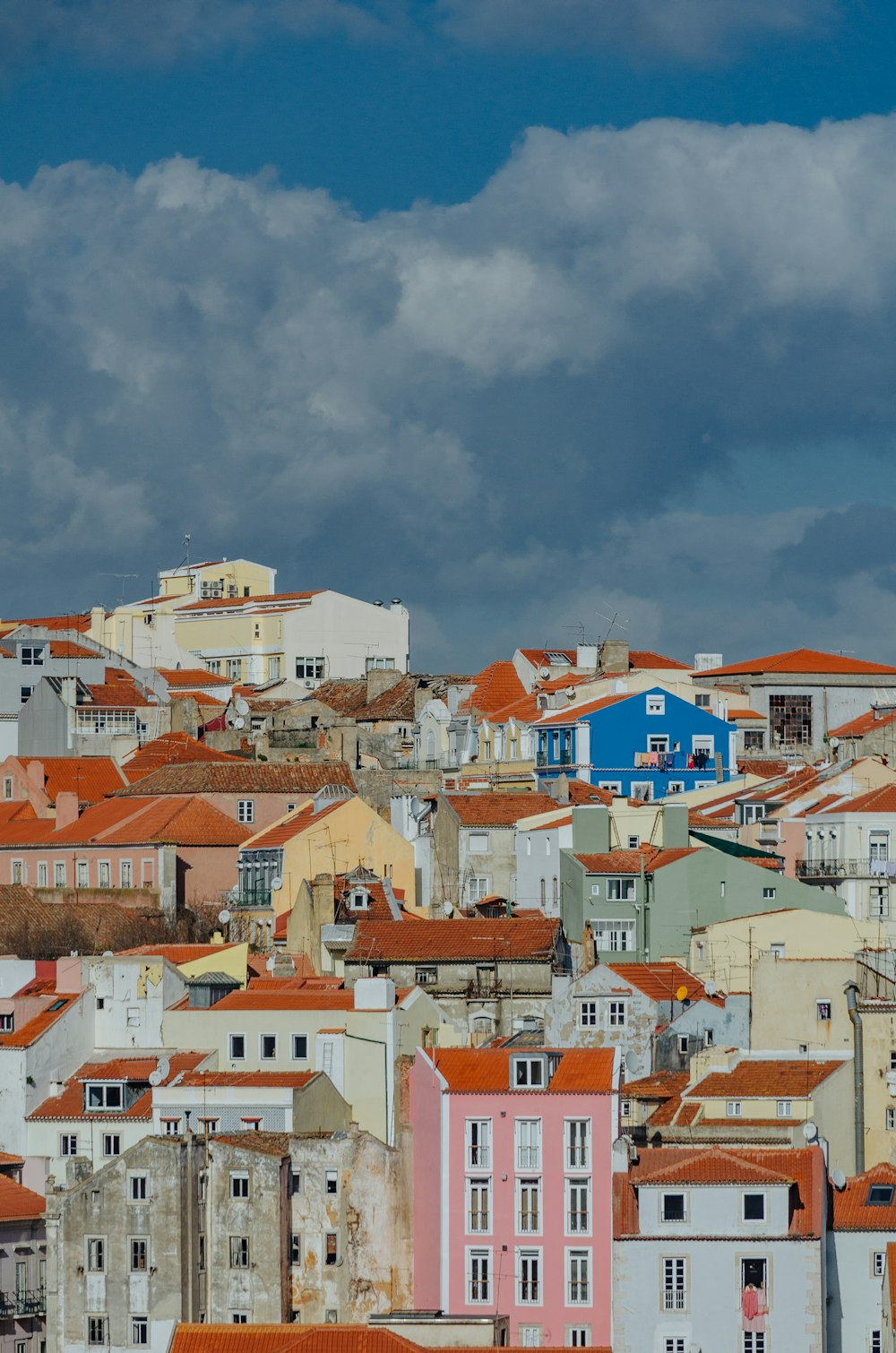 white and orange concrete buildings under gray clouds