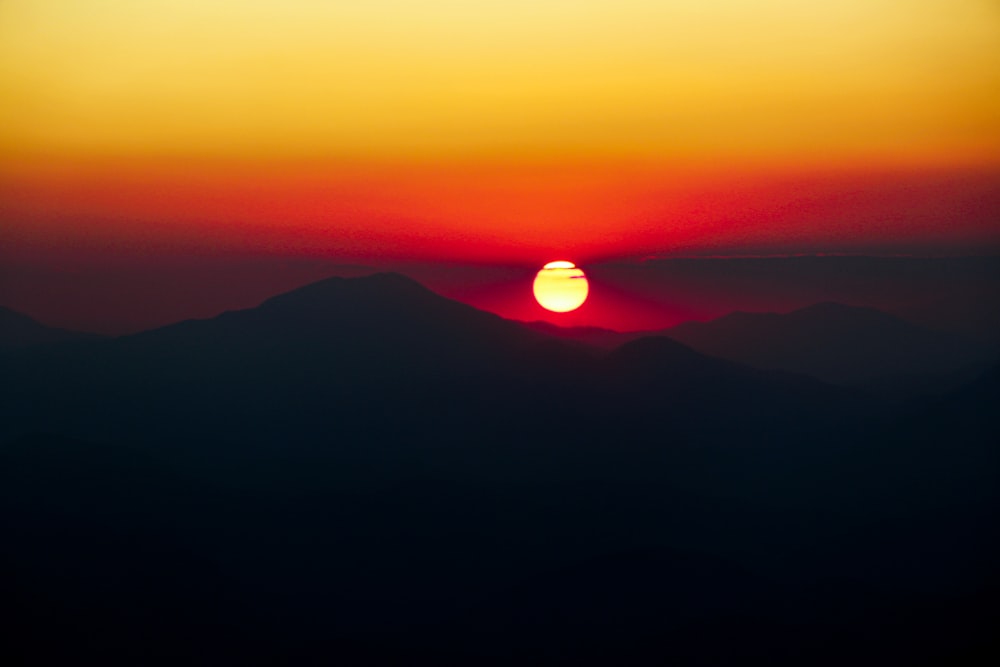 silhouette of mountains and orange sky