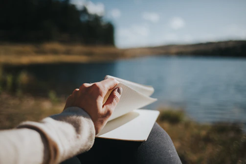 A peaceful setting with a person journaling outdoors, reflecting on health goals.