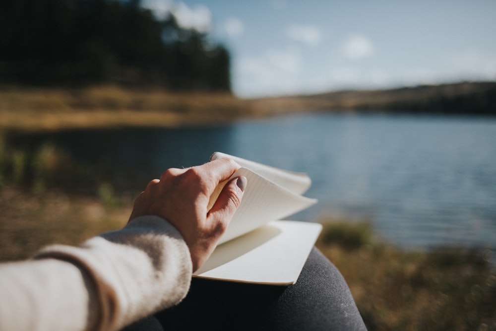 person holding white book