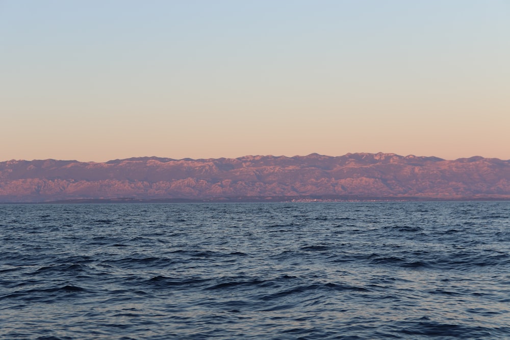 body of water and brown mountains