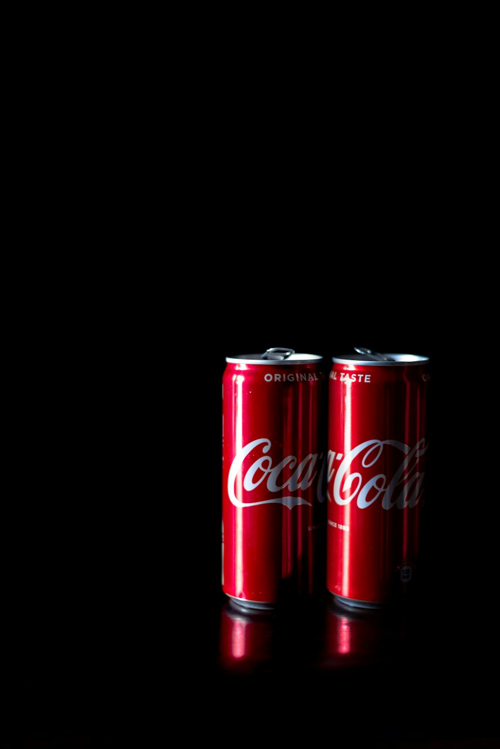 two Coca-Cola cans