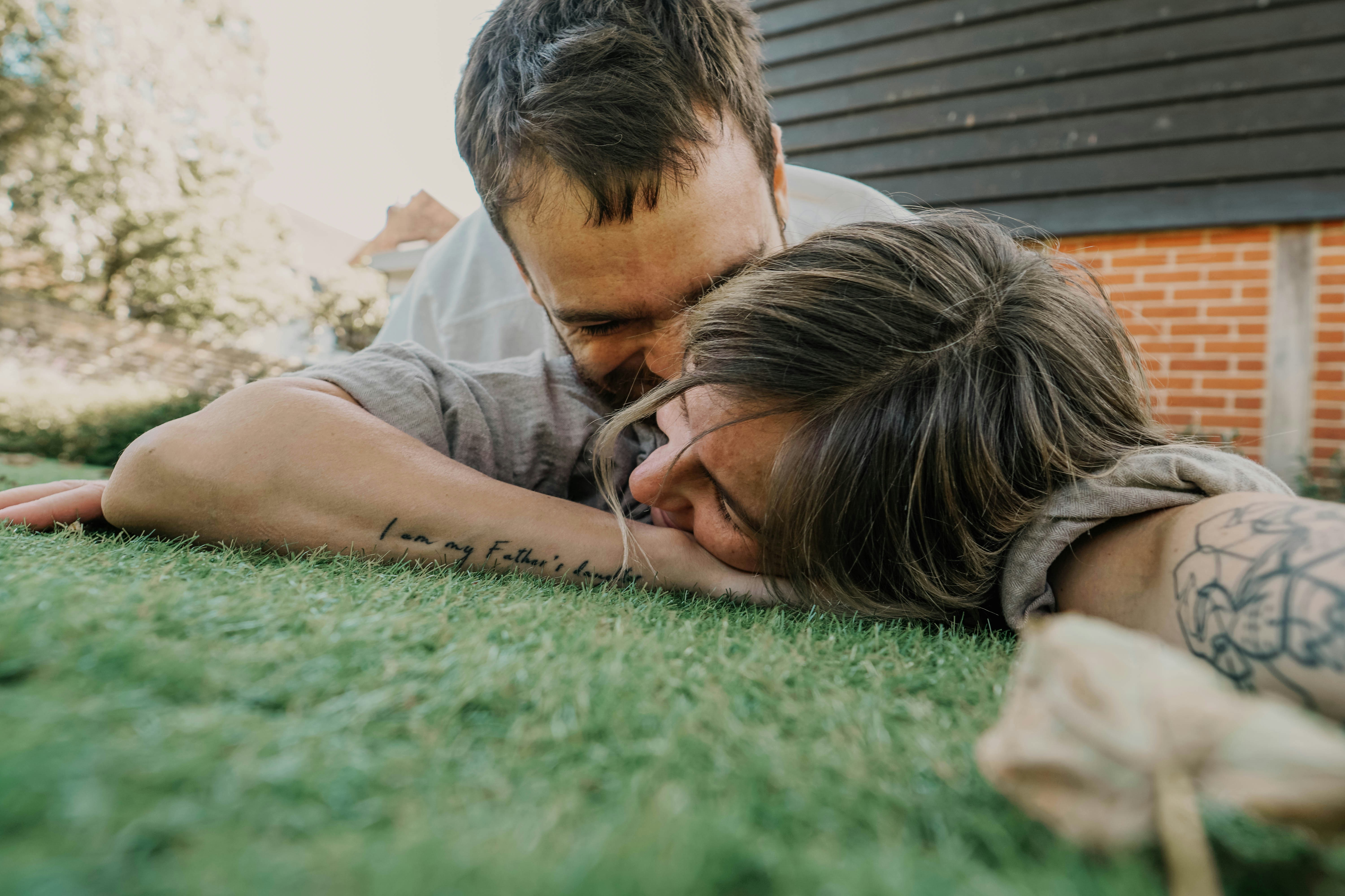 woman lying on green grass field during daytime