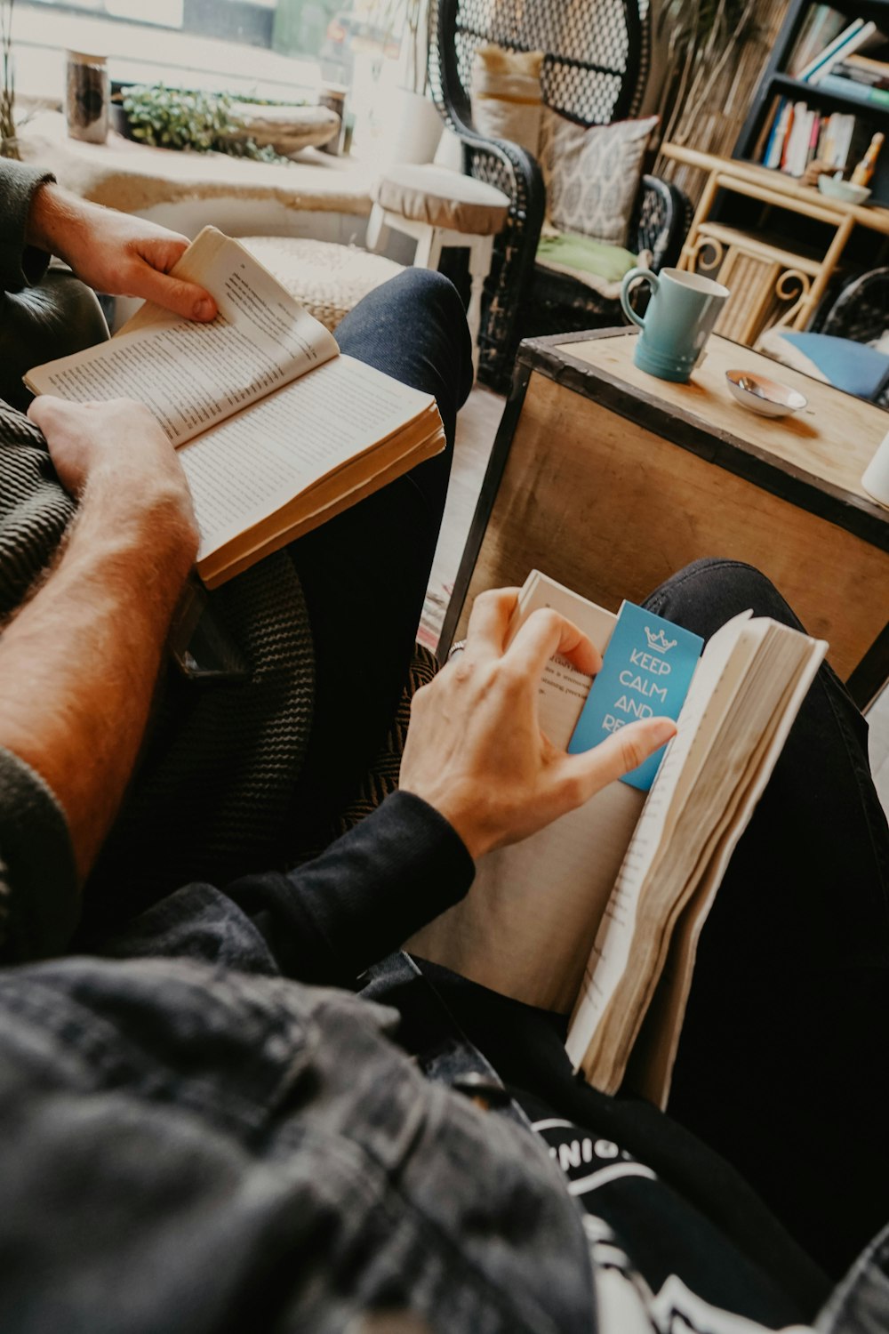 two person reading books inside room during daytime