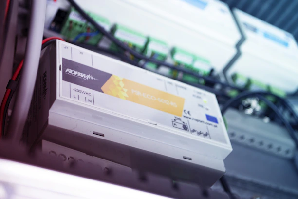 Close-up of a telecom rectifier unit with LED indicators glowing softly.