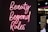 Neon pink script reads 'Beauty Beyond Rules' against a dark background with a partially visible sign in the background.