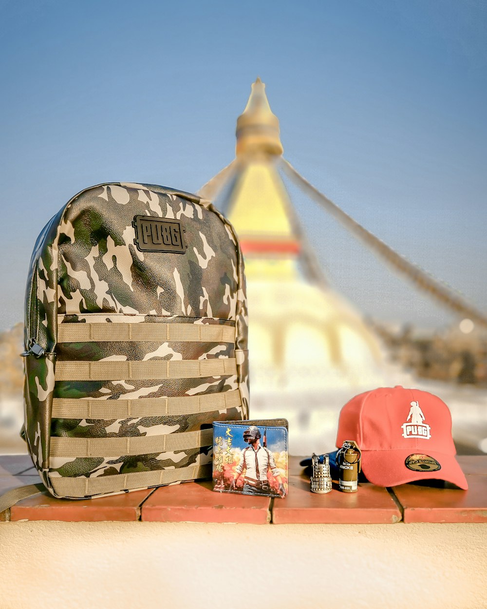 gray camouflage backpack beside cap