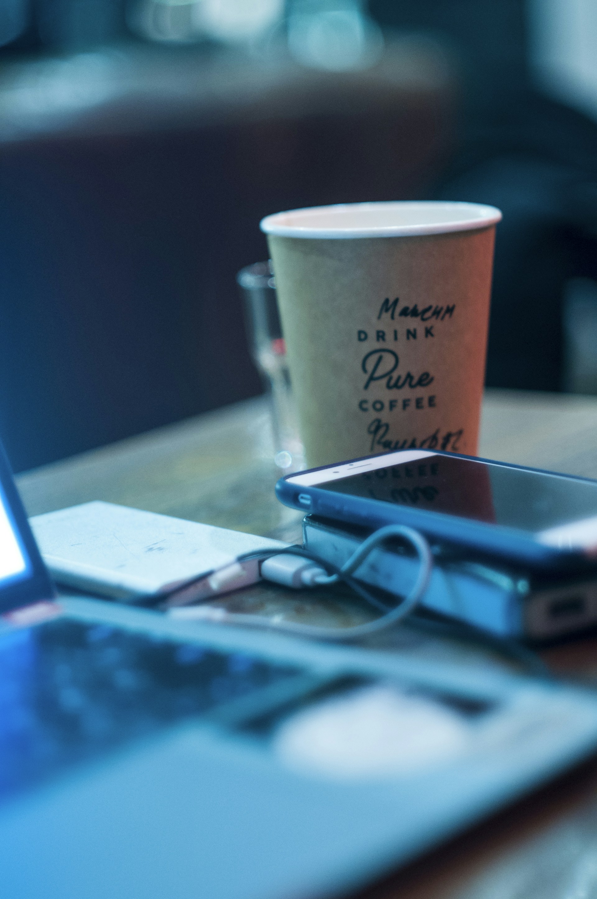 Close-up of downloadable IELTS practice PDFs displayed on a smartphone screen with a cup of coffee nearby.