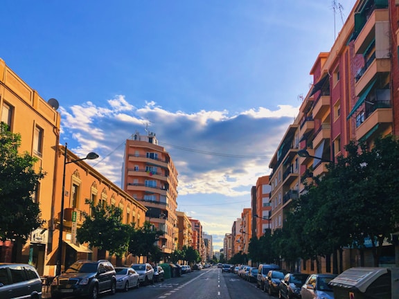A vibrant neighborhood street view showcasing premium residential buildings and tree-lined sidewalks.