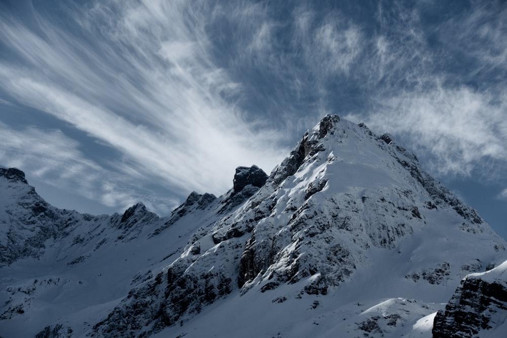 montanha coberta de neve sob o céu branco e azul durante o dia