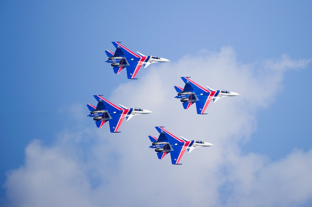 four white, blue, and red jet fighters
