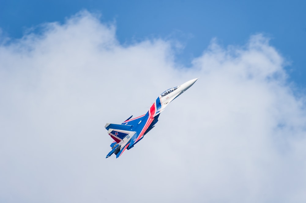 blue, red, and white jet fighter plane