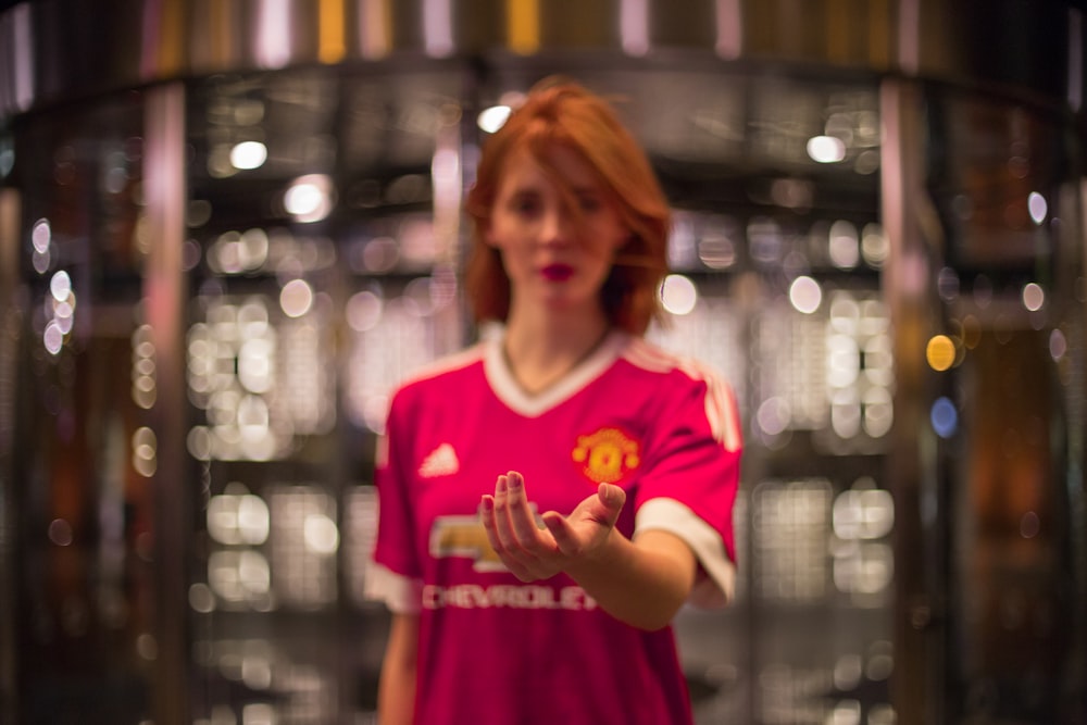 bokeh photography of woman in red V-neck top